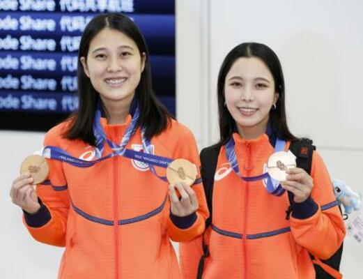 羽田空港に到着しメダルを披露する、ノルディックスキージャンプ女子の丸山希(左)と高梨沙羅=18日午前