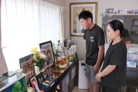 　久保田大治郎さんの遺影を見つめる母真実さん（右）と父純司さん＝８月、東京都八王子市