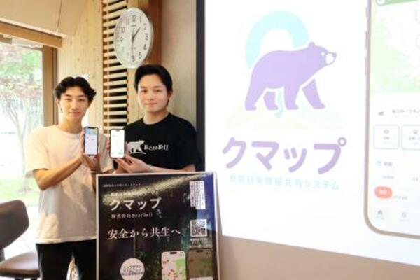 クマの目撃情報をリアルタイムで共有できるスマートフォンアプリ「クマップ」をリリースした「BearBell」の服部悠大さん(右)=13日午後、秋田市の国際教養大