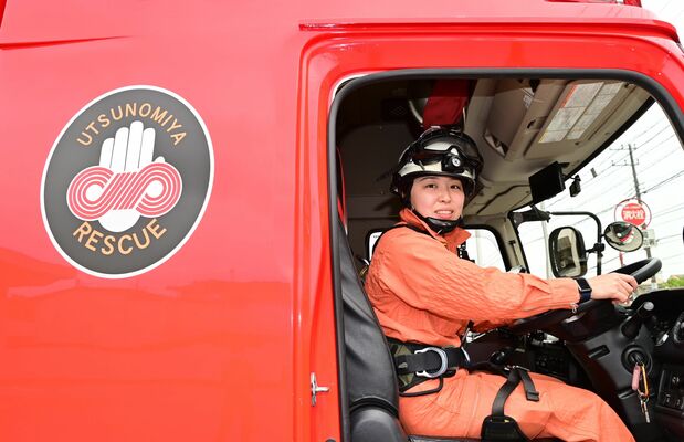 赤いロープのシンボルマーク（車体）の重みを感じて任務に当たる青木さん