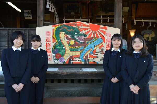 りりしい竜が描かれた大絵馬と制作した部員たち