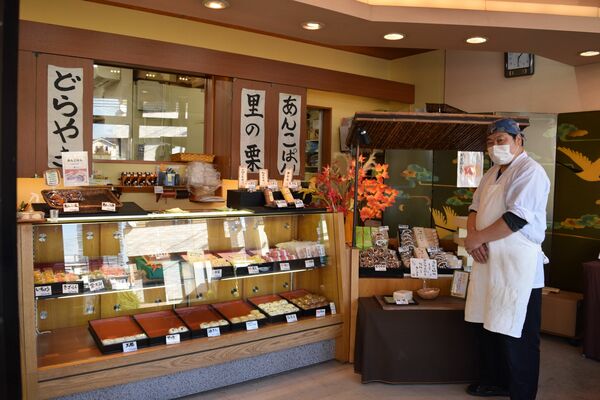 さまざまなお菓子が並ぶ店内と金子さん