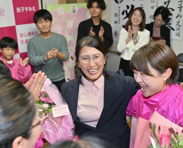 初当選し、花束を手に支持者と笑顔で話す益子純恵氏(中央)=19日午後9時、那珂川町馬頭、磯真奈美撮影