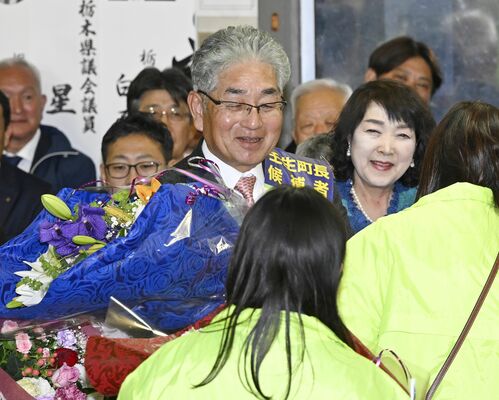 無投票で５選が決まり、支援者から花束を受け取る小菅一弥氏（中央）＝24日午後６時10分、壬生町福和田、森田大地撮影
