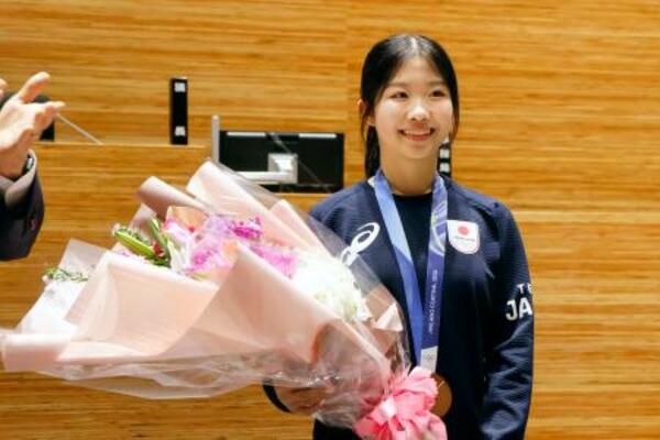 　千葉県市川市の市民栄誉賞を贈られ、花束を手に写真に納まる中井亜美選手＝２９日午前、市川市役所