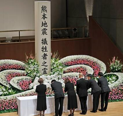 熊本県益城町で開かれた追悼式で献花する遺族ら=12日午前