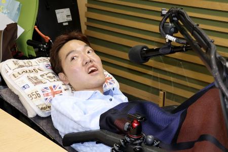 　ＦＭ番組「寝たきり社長のおはようエール」の収録に臨むパーソナリティーの佐藤仙務さん＝５月、名古屋市
