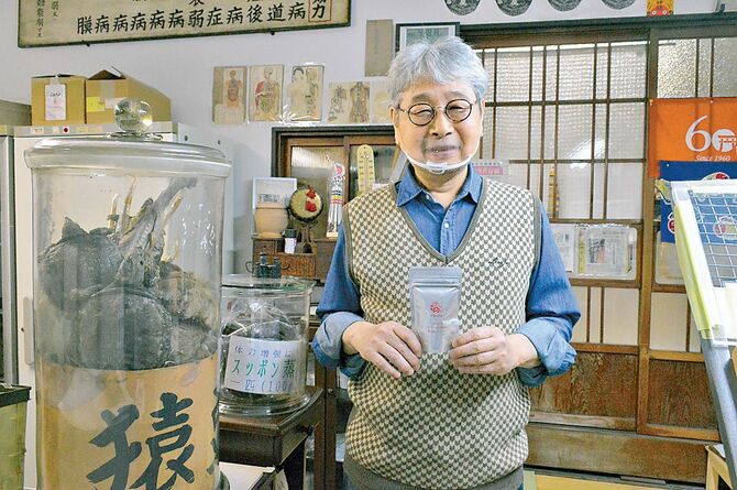 「スッポン純油」を手にとってもにこやかな４代目手塚豪さん