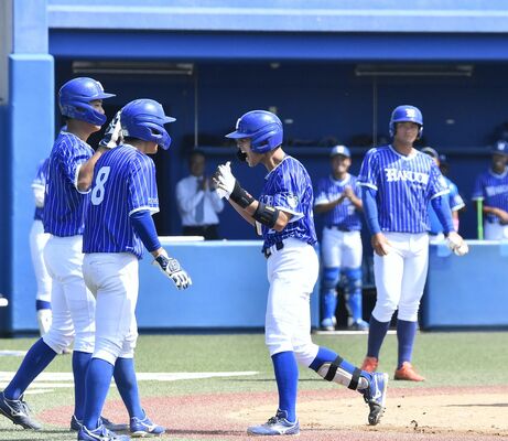 ３回、白鴎大の吉澤（左から３人目）が３点本塁打を放ちナインに迎えられる＝白鴎大グラウンド、井上孝男撮影
