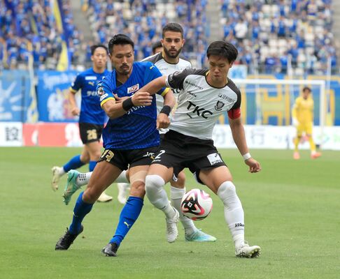 前半、競り合う栃木ＳＣのＤＦ平松（右）＝レゾナックドーム大分