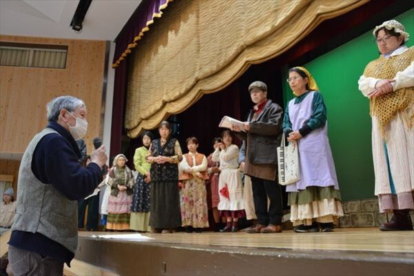 通し稽古で演出の江藤さん（手前）の指示を真剣な表情で聴く出演者たち