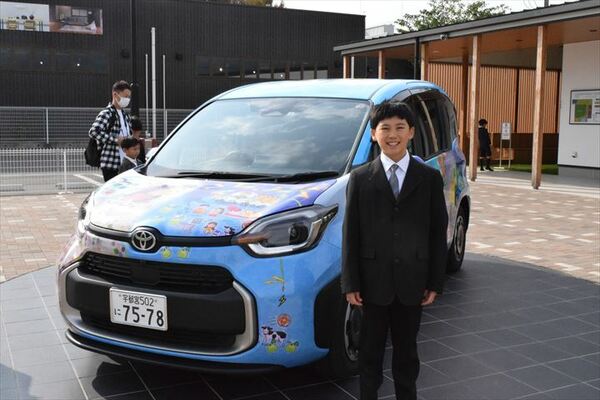 県知事賞を受賞した湯澤君（右）と全受賞作がラッピングされた車＝５日午前、宇都宮市インターパーク６丁目