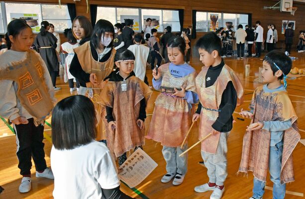 短大生のサポートを受けながら、自然素材で音楽を作る児童