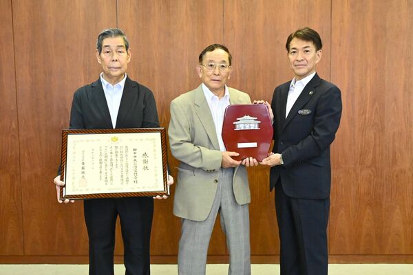 早川市長（右）から記念品を贈られた鈴木会長（中央）