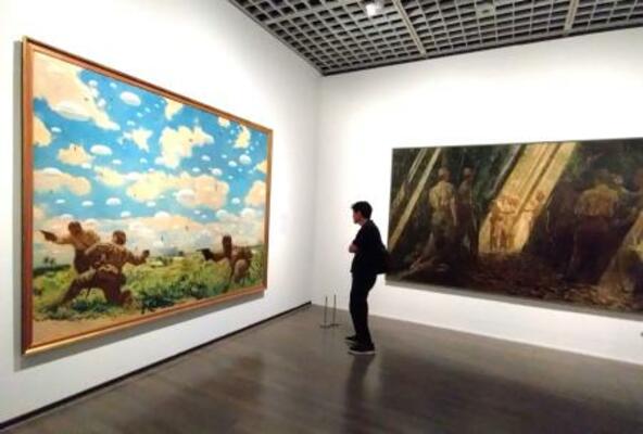 　鶴田吾郎「神兵パレンバンに降下す」（左、１９４２年、東京国立近代美術館蔵、無期限貸与）と田村孝之介「佐野部隊長還らざる大野挺身隊と訣別す」（右、１９４４年、東京国立近代美術館蔵、無期限貸与）