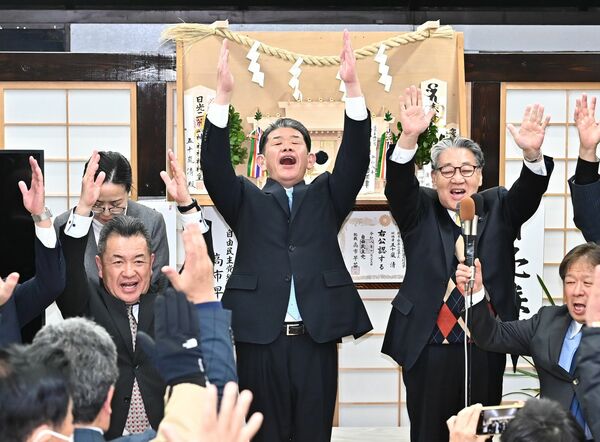 小選挙区での初当選を確実にし、万歳する五十嵐清氏（中央）＝８日午後８時20分、鹿沼市万町、増田康志朗撮影