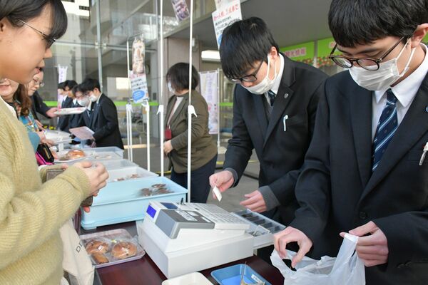 パンなどを販売する宇都宮青葉高等学園の生徒ら＝５日午前、宇都宮市本町