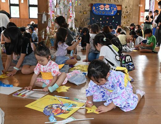 星型の画用紙を使って「星のつえ」を作る子どもたち