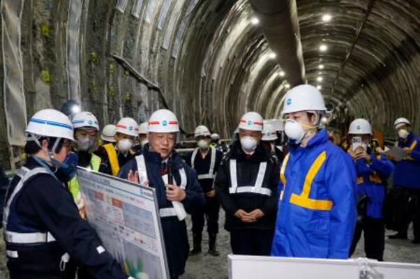 北海道新幹線の渡島トンネル内で、工事状況の説明を聞く北海道の鈴木直道知事(手前右)=21日午前