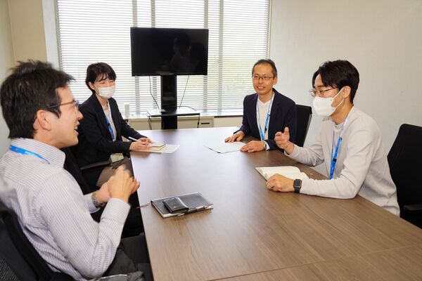ビジネスカジュアル導入に伴い、襟のないシャツで打ち合わせに臨む足銀の行員（右）＝宇都宮市