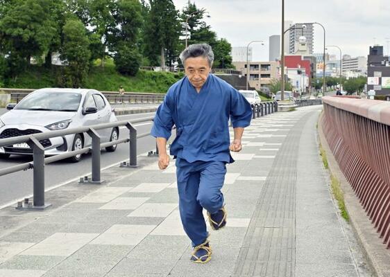 わらじを履いて江戸時代の走り方を再現する大場さん＝小山市小山