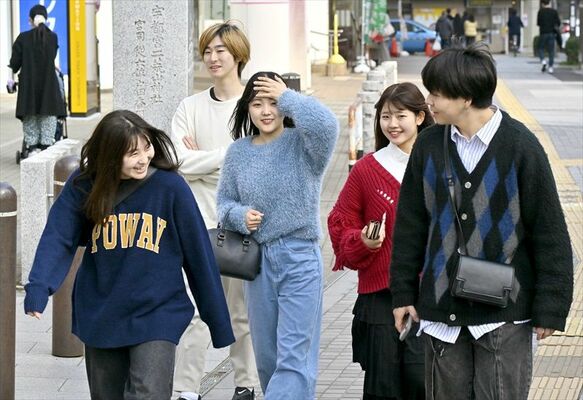 風を受け髪を押さえて歩く通行人ら＝15日午後２時、宇都宮市馬場通り１丁目