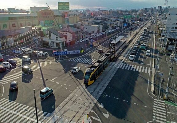 西日を受けて長く伸びるライトラインの影＝22日午後３時５分、宇都宮市陽東５丁目、ドローンから