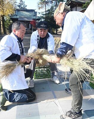 境内で新年のしめ飾りを作る氏子