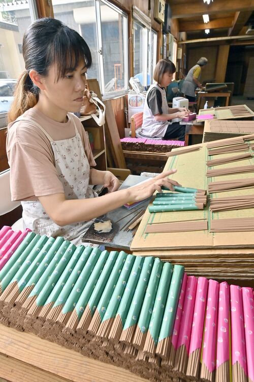 手作業で束ねられ積み上がった杉線香=2日午後2時40分、日光市小百