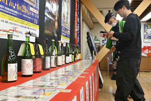 説明を受けながら銘柄を選ぶ観光客