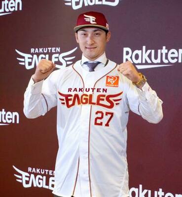 楽天の入団記者会見でユニホームを着てポーズをとる、DeNAから移籍した伊藤光=10日、楽天モバイルパーク宮城