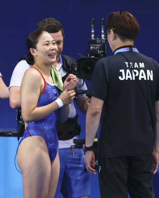 女子板飛び込み準決勝の演技を終え、馬淵崇英コーチ（右）と話す榎本遼香＝パリ郊外（共同）