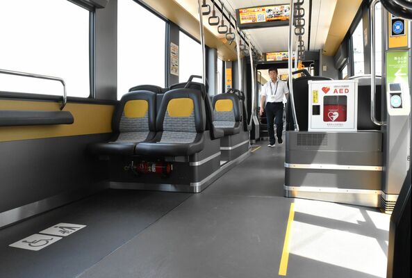 ＬＲＴ車両のボックスシート周辺に設けられたフリースペース（手前左）。車内が緩やかな坂になっていることを示す黄色の線（手前右）