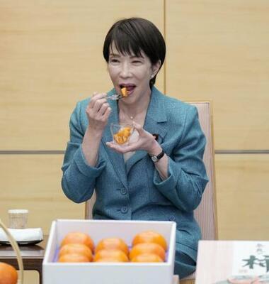 　贈呈された奈良県特産の柿を試食する高市首相＝１９日、首相官邸