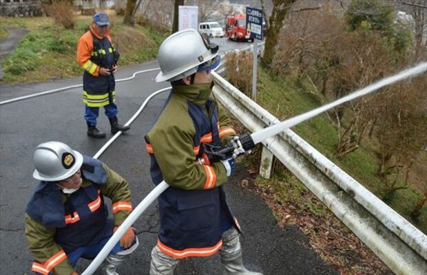 斜面の長い距離を中継して放水する団員