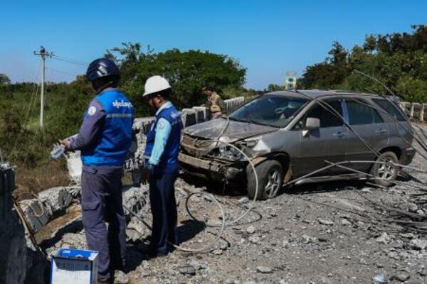 　２０日、カンボジア北西部でタイ軍の戦闘機による空爆を受けた橋を調べる政府職員ら（ゲッティ＝共同）