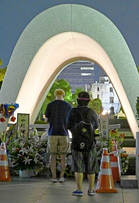 未明の時間帯、慰霊碑に手を合わせる人たち＝６日午前２時15分、広島市