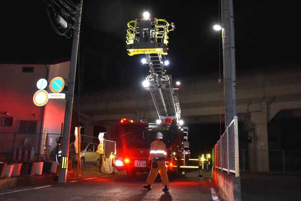 運転を見合わせた電車内からはしご車で移動困難者を救助した東武日光線の現場=11日午後8時40分、栃木市境町