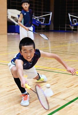 男子６年以下ダブルス　押久保・北川（五代・みはら）組－山口・山崎（ＲｏｚｅＴｓ　Ｊｒ）決勝　第２ゲーム、北川が踏み込んでレシーブ＝日環アリーナ栃木