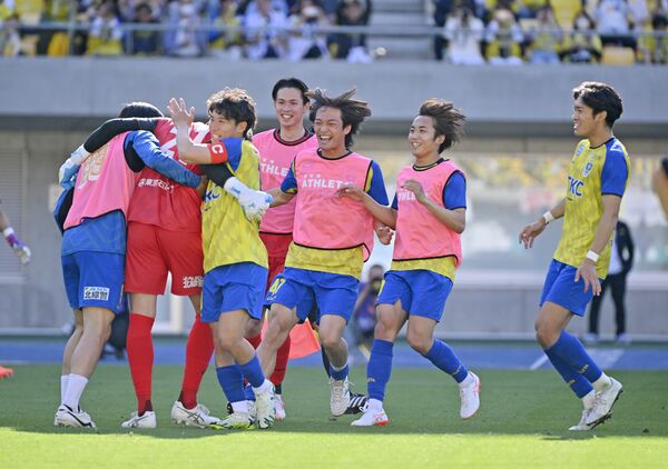 ＰＫ戦を制し、栃木ＳＣのＧＫ桜庭（左から２人目）の元に笑顔で集まるＭＦ大曽根（同３人目）ら＝カンセキスタジアムとちぎ、森田大地撮影