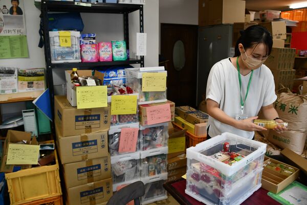 寄贈された食品の賞味期限などを確認するフードバンク担当者＝２日午前、宇都宮市塙田２丁目