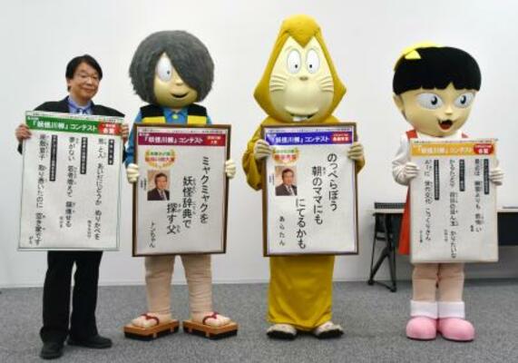 　「第２０回妖怪川柳コンテスト」の入賞作を発表する関係者と着ぐるみの鬼太郎ら＝１９日午前、鳥取県境港市