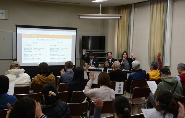 「闇バイト」の求人かどうかを見抜くクイズで挙手する参加者=22日午後、宇都宮市下桑島町