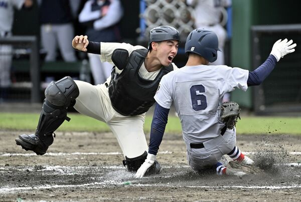 ２回、作新の捕手・大村（左）が右飛で本塁を突いた相手の二走をタッチアウト＝茨城県のひたちなか市民球場、森田大地撮影