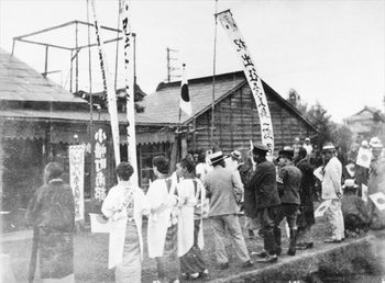 出征は郷土の誉れだった。のぼり旗を掲げ、日の丸を手に出征者を送る宇都宮市小幡町の人々(「写真でつづる宇都宮百年」より)