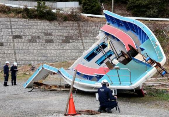 　事故に遭った遊漁船を調べる運輸安全委員会の船舶事故調査官＝２４日午前、三重県鳥羽市