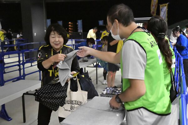 古着から作られたタオルを手渡される入場者＝９月20日午後、カンセキスタジアムとちぎ