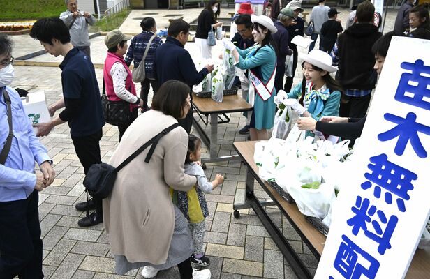 マロニエメイツからラズベリーの苗を受け取る募金協力者