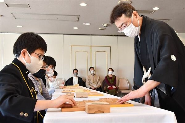 塚田九段（右）と多面指しで対局する子どもたち