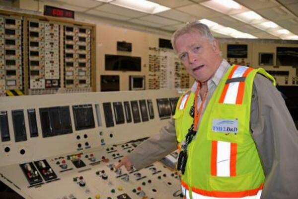 　スリーマイルアイランド原発２号機の中央制御室で、事故や廃炉作業の状況を説明するエナジーソリューションズ社の関係者＝４月、米ペンシルベニア州（共同）